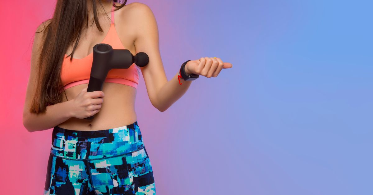Kvinde bruger massagepistol på overarmen